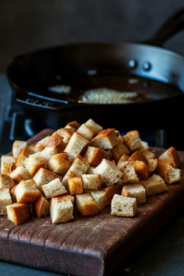 Brotwürfel werden in einer Pfanne mit heißem Öl goldbraun geröstet.